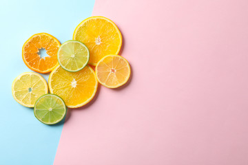 Citrus fruits slices on two tone background, top view