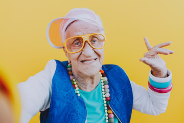 Funny grandmother portraits. 80s style outfit. trapstar taking a selfie on colored backgrounds....