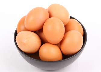 brown eggs in black bowl on white background 