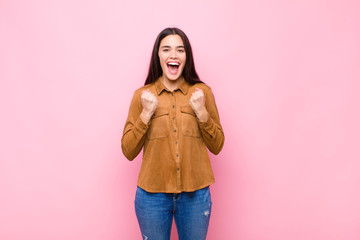 young pretty woman shouting aggressively with annoyed, frustrated, angry look and tight fists,...