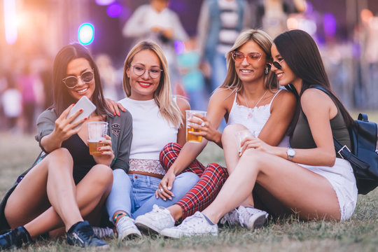 Four friends taking selfie at the music festival