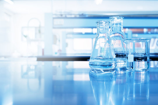 water in beaker and flask glass in chemistry blue science laboratory background