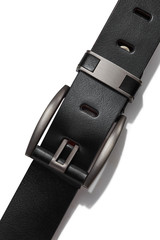 Cropped shot of a black leather belt decorated with a metal buckle and a loop with leather inserts....