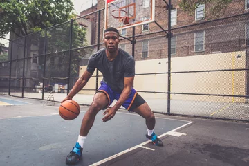 Gardinen Basketball player training on a court in New york city © oneinchpunch