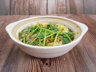 parsley Instant noodles  in a dish filled with boiling water.Chinese tableware