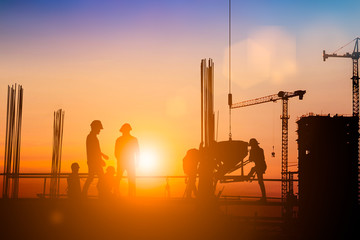 Silhouette of Survey Engineer and construction team working at site over blurred  industry...