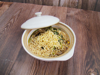 Lift the lid.Instant noodles  in a dish filled with boiling water.Chinese tableware