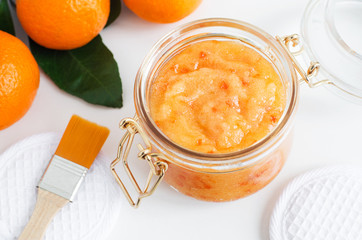 Homemade tangerine facial mask (exfoliating sugar scrub) in the glass jar. Mandarin orange DIY...