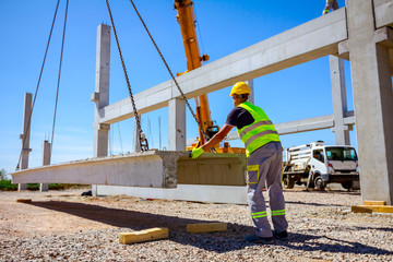 Workers are helping crane from the ground, keep balance and direction