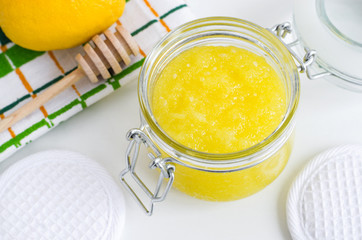 Homemade lemon and honey facial mask (sugar scrub) in the glass jar. DIY cosmetics and spa recipe. Top view, copy space.