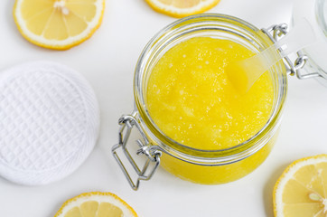 Homemade lemon facial mask (sugar scrub) in the glass jar. DIY cosmetics and spa recipe. Top view,...