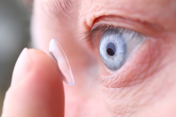 Man putting on soft contact lens