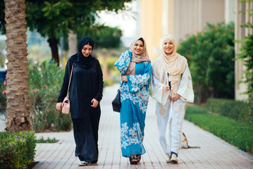 Three women friends going out in Dubai. Girls wearing the united arab emirates traditional abaya