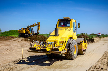 Plate compactor is mounted on road roller to compact soil at construction site