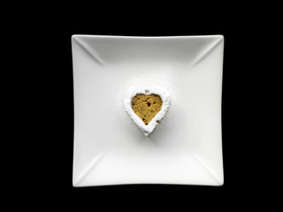 heart-shaped cake on a white plate on a black background