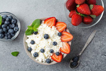 Healthy breakfast cottage cheese with strawberries, blueberries and mint, selective focus. 