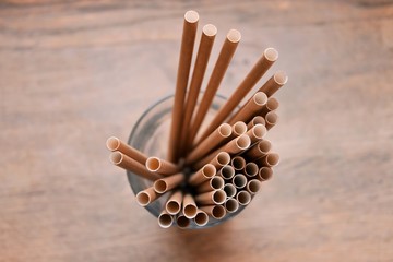 Eco friendly Reusable Straws in the cardboard cup with selective focus and blurred ba. Paper cocktail tubes. Kraft paper straw for drinking coffee or tea. Disposable cocktail tube. 