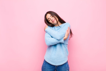 young pretty woman feeling in love, smiling, cuddling and hugging self, staying single, being...