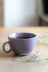 Cup of tea and gypsophila flowers on wooden table. Selective focus. 