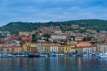 Fototapeta na wymiar Porto Santo Stefano old town view from the water at early norning light. Toscana, Italy