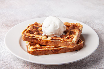 Belgian waffles with ice cream on a white plate. Homemade waffer craft background.
