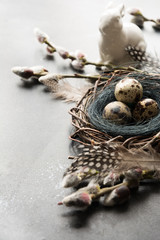 Easter bunny with eggs in nest, spring willow on grey. Space for text. Easter composition.