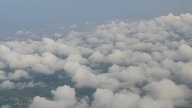 The plane flies over Dutch cities, the green fields of multicolored tulips. Holland from above in clouds