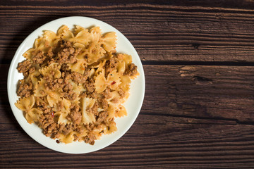 fresh delicious nutritious pasta with pork meat on a wooden background . the view from the top. photo for banner, place for text