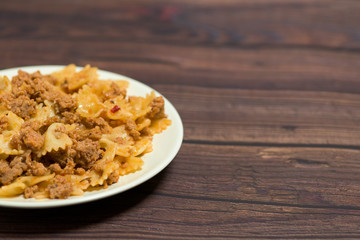 fresh delicious nutritious pasta with meat on a wooden background . the view from the top. photo for banner, place for text . close up