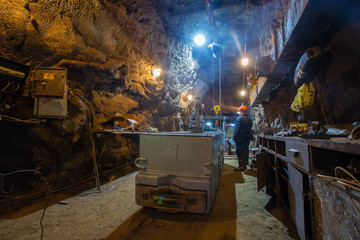 Underground gold mine miners repairs the locomotive