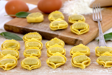 Tortellini with ricotta and spinach stuffing, traditional italian pasta, on a woodem table