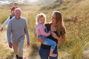 Multi-Generation Family Walking Along Path Through Sand Dunes Together