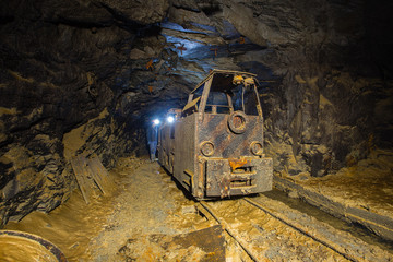 Underground gold mine shaft tunnel drift with old electric locomotive