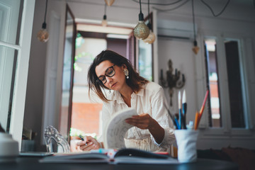 Young creative woman working in designer agency, female small business owner working on social media strategy while sitting in modern loft studio, Successful Owner Project Creative People