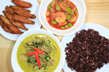 Meal of Thai Local food with Green Beef Curry, Deep Fried Spicy Chicken Wings, Stir Fried Parkia Nuts with Shrimps and Rice