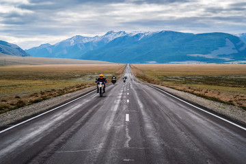 Fototapeta premium Motorcycle column traveling along the Chuysky tract at dawn, landscape with a highway. Russia, mountain Altai