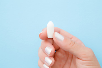 Young woman fingers holding white medical candle. Medical, pharmacy and healthcare concept....