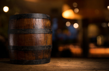 Beer barrel with beer glasses on a wooden table. The dark brown background.