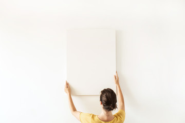 Blank canvas with empty mockup copy space in female hands. Minimal art concept.