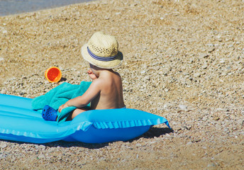 Cute baby with hat on summer beach