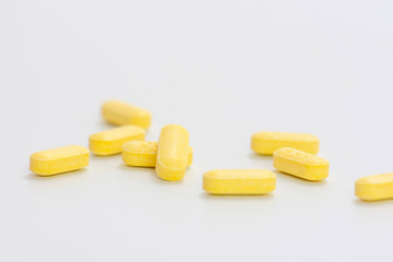 Yellow pills isolated on white background. Vitamin C tablets 500 mg.