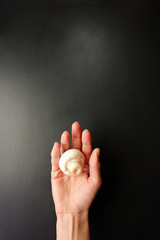 White mushroom in the hand. Black background, empty place for text