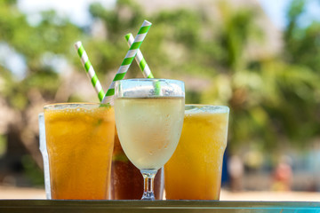 Lots of tropical cocktails and fresh juices in glass goblets on a tray, island of Zanzibar, Tanzania, Africa. Summer cooling cocktails close up