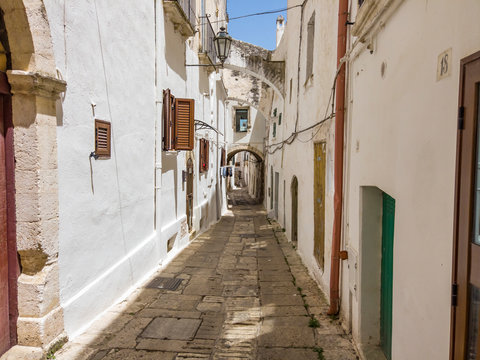 Italy, Province of Brindisi, Ostuni, Empty alley between old white-colored city houses