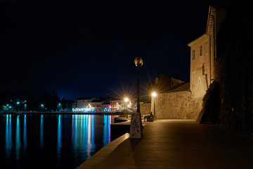Promenade along the Adriatic Sea in the old town of Porec in Croatia at night 
