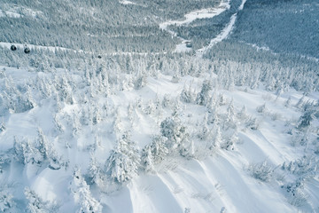 Ski lift in snowfall in mountains ski resort Sheregesh, Russia White winter aerial view  landscape with chairlifts  and snow covered fir tree forest