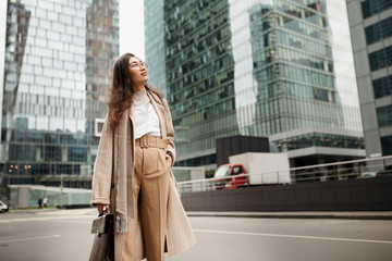 Beautiful Asian girl Manager looks admiringly at the business skyscrapers of Moscow city, going to get a job
