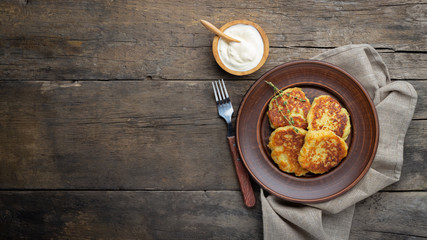 Fried potato pancakes - draniki or deruny on a wooden table. Rustic style. Top view with copy space.