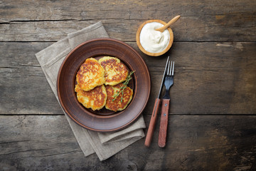 Fried potato pancakes - draniki or deruny on a wooden table. Rustic style. Top view with copy space.
