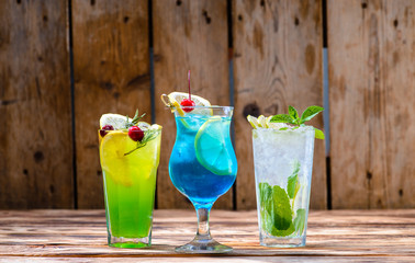 green fairy cocktails with lemon and absinthe, a blue lagoon and mojito in a bar